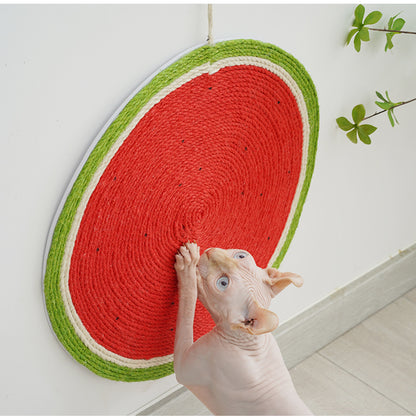 Sphynx cat using a watermelon-shaped cat scratching mat on a wall