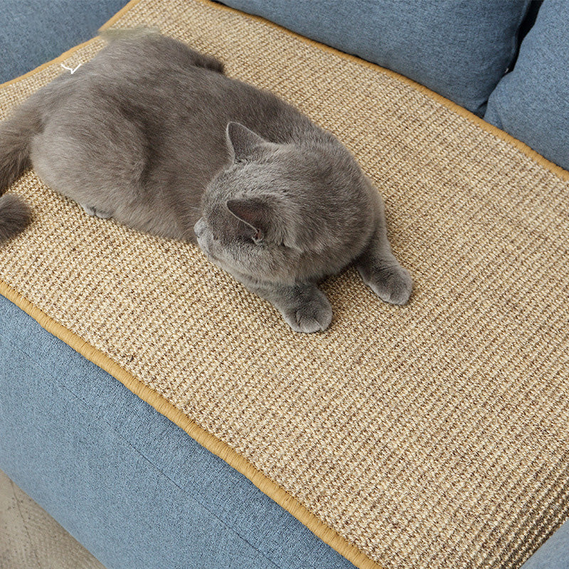 Cat using a sisal scratching mat on furniture