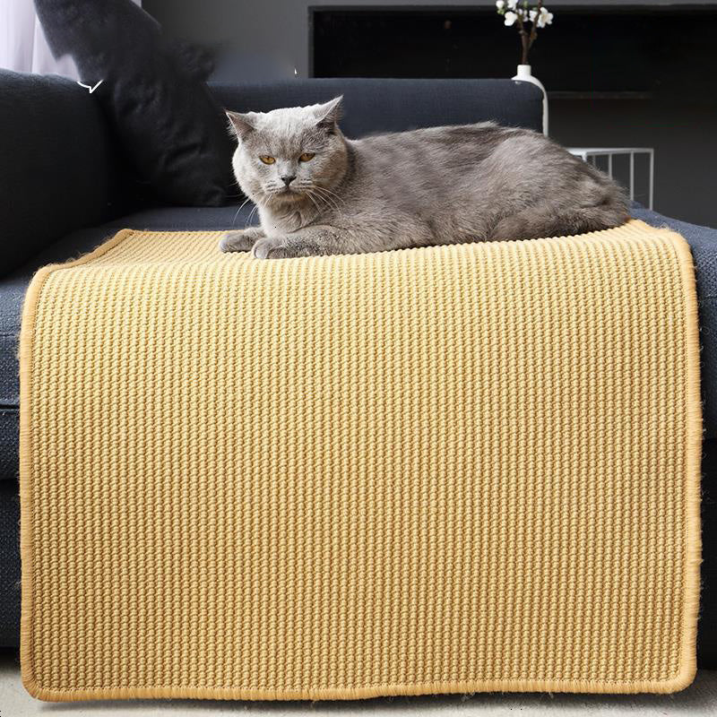 Cat using a flexible sisal scratching mat on a sofa
