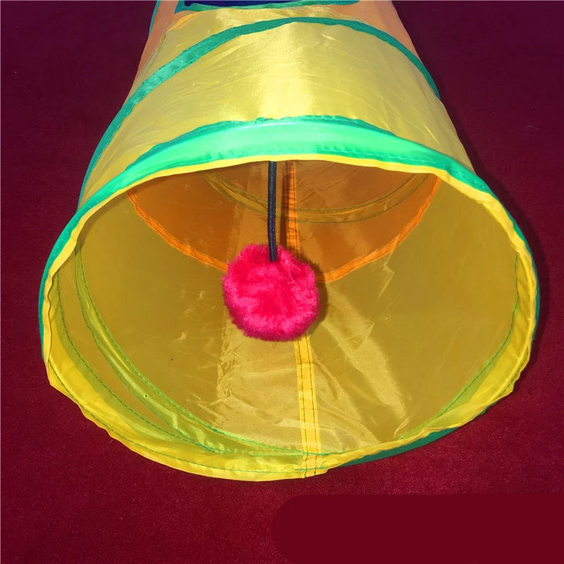 Inside view of a rainbow cat tunnel with hanging pom-pom toy